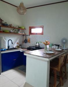 a kitchen with blue cabinets and a counter top at anik homestay & dormy Batukaras in Batukaras