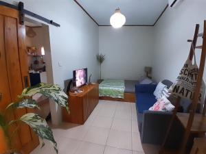 a living room with a couch and a bed at anik homestay & dormy Batukaras in Batukaras
