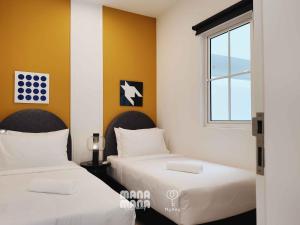two beds in a room with a window at Stallionz by MyKey in Ipoh +65 photos