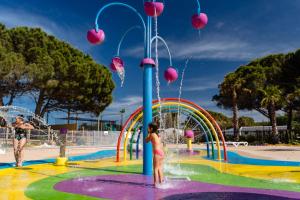a girl is standing in front of a water park at Eden 1708 in Canet-en-Roussillon