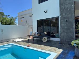 a swimming pool with a table next to a house at Authentica Private Villa by Oceanaxe Holidays in Calodyne