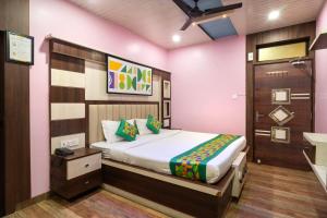 a bedroom with a bed in a pink room at Treebo Saumendra Residency in Varanasi
