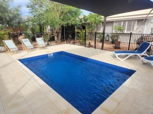 a swimming pool with blue water in a yard at 16 Stokes-Hughes Street - With Pool in Exmouth