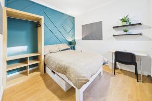 a small bedroom with a bed and a desk at The Phoenix in Swansea