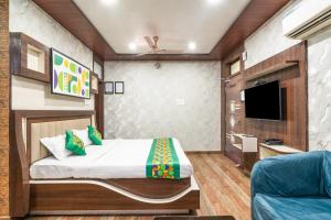 a bedroom with a bed and a tv and a couch at Treebo Saumendra Residency in Varanasi +41 photos