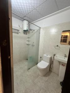 a bathroom with a toilet and a shower and a sink at Shivara Homes in Jaipur +12 photos