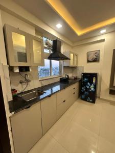 a kitchen with white cabinets and a sink and a window at Shivara Homes in Jaipur