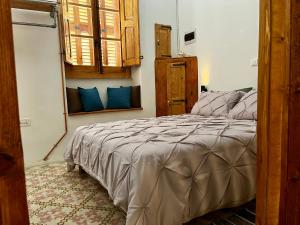 a bedroom with a large bed with blue pillows at Magdalena in Cospicua