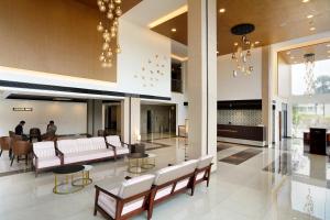 a lobby with couches and chairs and a table at Parays Fernwoods in Mannārakkāt