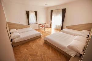 a bedroom with two beds and a table at Postojna Rooms in Postojna