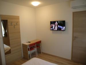 a room with a small table and a television on the wall at Postojna Rooms in Postojna +61 photos