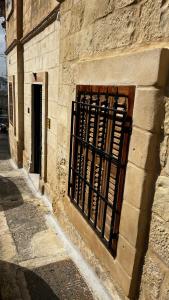 a stone building with a gate and a door at Magdalena in Cospicua