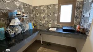 a kitchen counter with a sink and a window at Kinara by The Ashram in Bīr