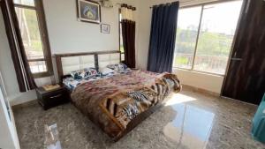 a bedroom with a bed with a tiger patterned bedspread at Kinara by The Ashram in Bīr