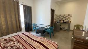a bedroom with a bed and a table and chairs at Kinara by The Ashram in Bīr