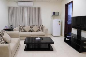 a living room with a couch and a coffee table at Almawasem Alarbaa for Serviced Apartments - Standard in Al Jubail