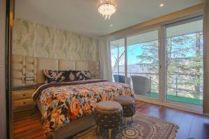 a bedroom with a bed and a large window at Samar Villa BnB in Shimla