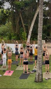 a group of people doing yoga in the grass at Surf Lodge Madiha in Matara