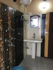 a bathroom with a sink and a shower at Hotel Aditya in Aritar