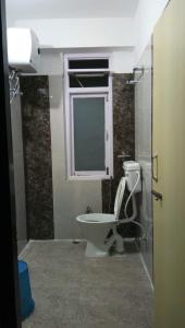a bathroom with a toilet and a window at Hotel Aditya in Aritar
