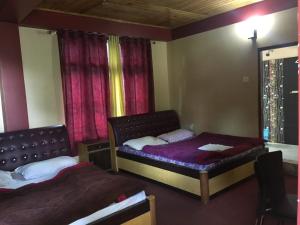 a bedroom with two beds and a window at Hotel Aditya in Aritar