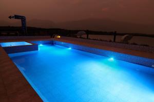 a swimming pool with blue lights in the night at Parays Fernwoods in Mannārakkāt