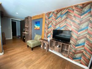 a living room with a tv and a wall with a mural at Tamnan Resort Pattaya in Ban Nong Chaeng