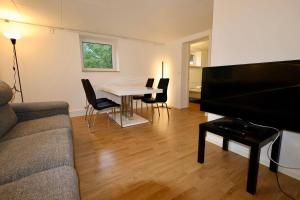a living room with a couch and a table and chairs at Workers Stay - Staff Apartment - Säve - Göteborg - Sverige in Säve