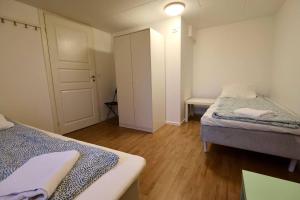 a small bedroom with two beds and a door at Workers Stay - Staff Apartment - Säve - Göteborg - Sverige in Säve