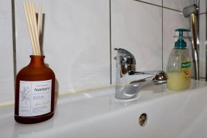 a bottle ofinator soap sitting on a bathroom sink at Workers Stay - Staff Apartment - Säve - Göteborg - Sverige in Säve +23 photos
