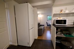 a kitchen with a white refrigerator and a microwave at Workers Stay - Staff Apartment - Säve - Göteborg - Sverige in Säve