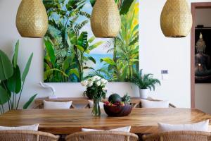 a dining room with a wooden table and plants at Luxury Sea View Jungle Beach Villa Walk to Beach in Ban Bang Po