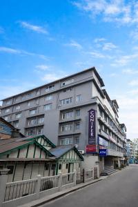 a large building on the side of a street at Conifer Suites & Spa Darjeeling in Darjeeling