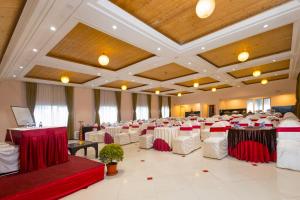 a banquet hall with white and red tables and chairs at Conifer Suites & Spa Darjeeling in Darjeeling