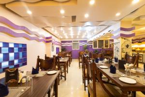 a restaurant with tables and chairs and purple walls at Conifer Suites & Spa Darjeeling in Darjeeling