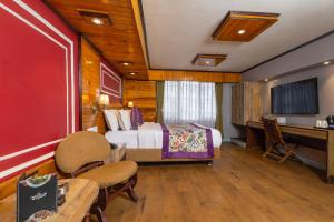 a hotel room with a bed and a desk at Conifer Suites & Spa Darjeeling in Darjeeling
