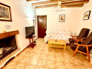 a living room with a couch and a tv at Rapia. Casa Beig 4 in Los Granadicos