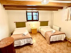 a room with two beds and a window at Rapia. Casa Beig 4 in Los Granadicos