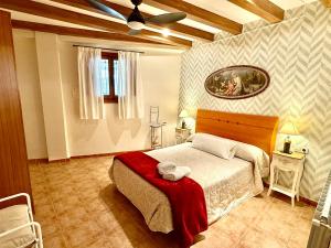 a bedroom with a bed with a red blanket on it at Rapia. Casa Beig 4 in Los Granadicos
