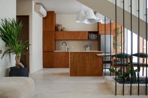 a kitchen with wooden cabinets and a kitchen island with a sink at Suom Apartments and Villas Canggu in Canggu