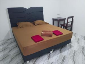 a bed with two towels and a table and chairs at EL Homestay Bunaken in Bunaken
