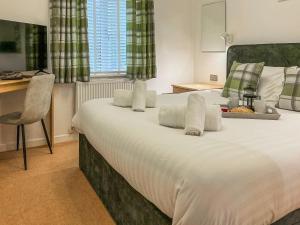 a bedroom with a large white bed with a chair at 9 Trehawks in Roche