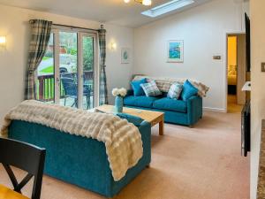 a living room with two blue couches and a table at 9 Trehawks in Roche