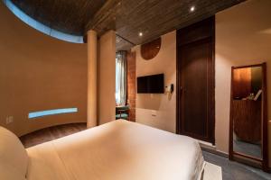 a bedroom with a white bed and a television at The Memory Danang Boutique in Danang