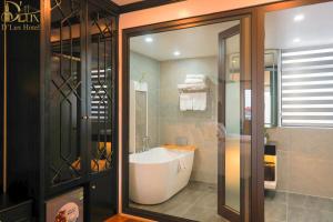 a bathroom with a bath tub and a shower at D'Lux Hotel in Hanoi