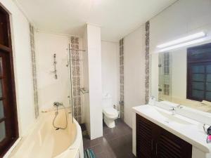 a bathroom with a tub and a toilet and a sink at Barnes Loft Mount in Mount Lavinia +44 photos