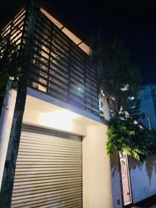 a building with a garage door and a tree at Barnes Loft Mount in Mount Lavinia