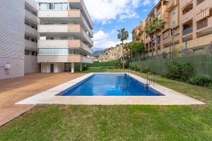 a swimming pool in a yard next to a building at Malvarrosa A103 in Fuengirola