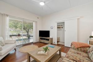 a living room with a couch and a tv at Misty Pines in Leura