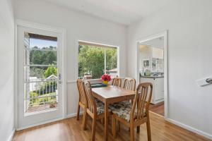 a dining room with a table and chairs and a window at Misty Pines in Leura +11 photos